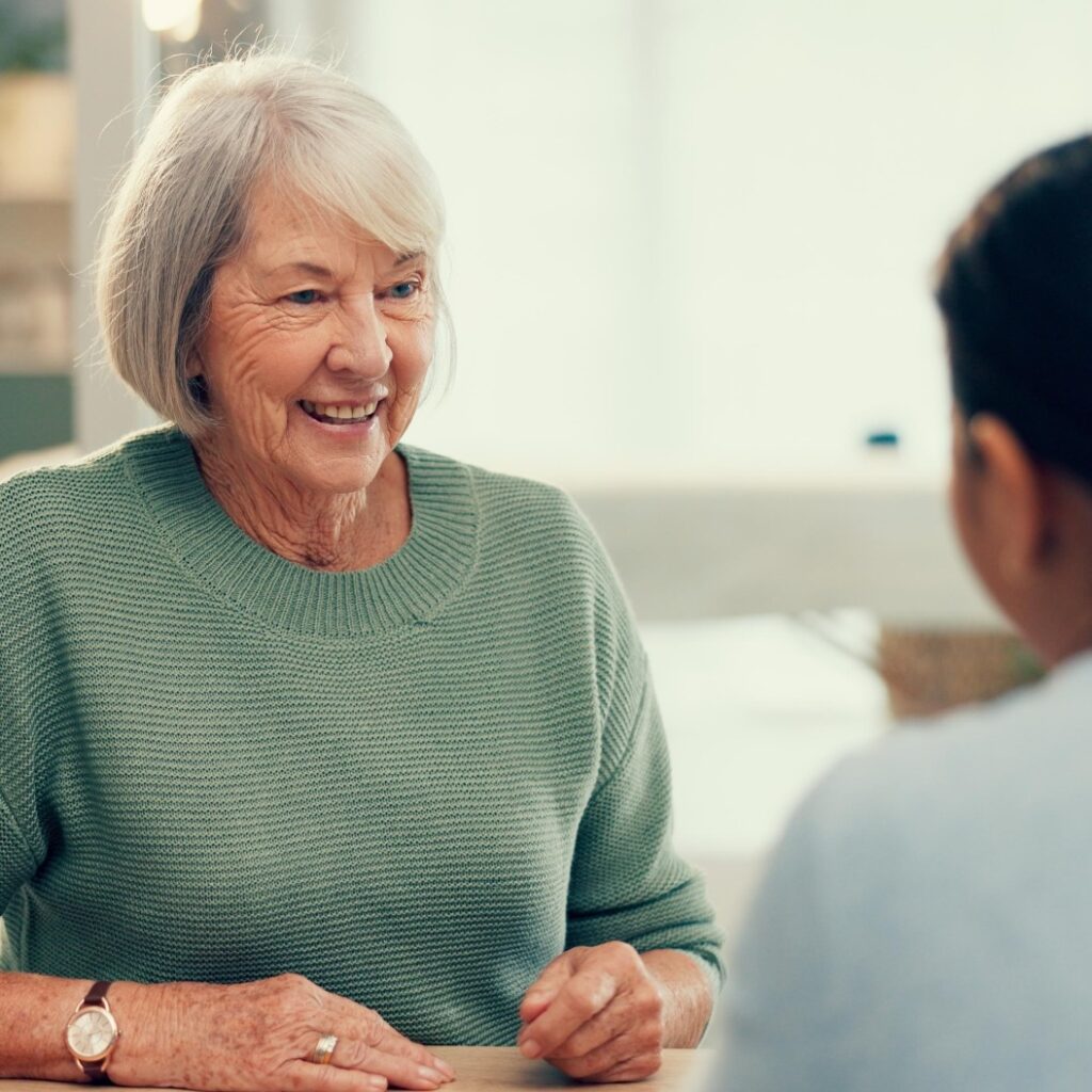 Begegnung, Gespräch oder psychologische Beratung mit einer älteren Dame zur Therapie, psychischen Gesundheit oder Unterstützung im Ruhestand. Zufriedene ältere Person im Gespräch, Psychologe hört zu oder Therapeut mit Unterstützung für ältere Patienten.